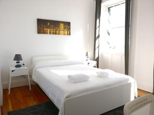 een witte slaapkamer met een bed en een raam bij Museum House in Funchal