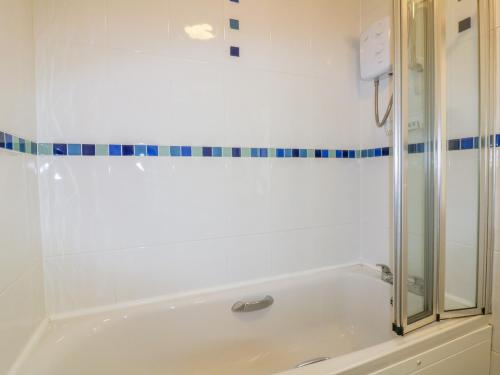a bathroom with a bath tub and a shower at Yellow Sands Apartment 7 in Padstow