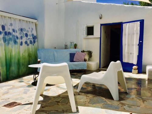 a living room with white chairs and a blue couch at Sandra Studio in Lachania