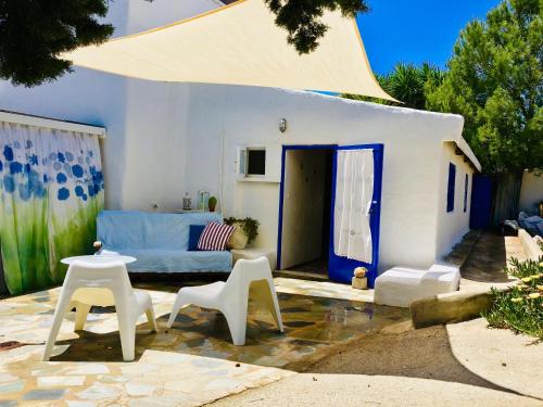 a living room with a blue couch and white chairs at Sandra Studio in Lachania