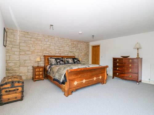 a bedroom with a wooden bed and a stone wall at Tuft House in York