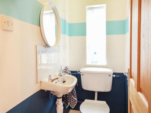 a bathroom with a white toilet and a sink at Bryn Ffynnon in Benllech