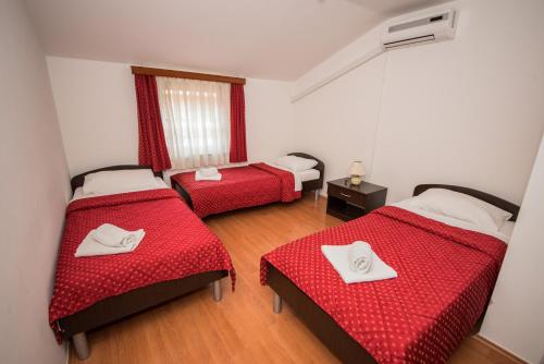 a room with two beds with red sheets at Lafodija in Međugorje