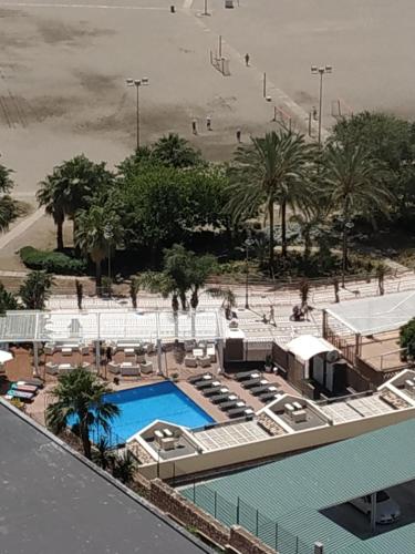 uitzicht op een zwembad met palmbomen en een strand bij Benalmadena Playa in Benalmádena