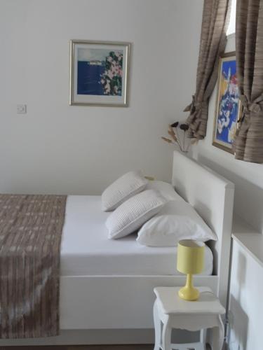 ドゥブロヴニクにあるStudio Marinの白いベッド(サイドテーブルに黄色のランプ付)
