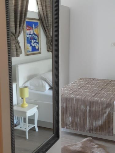 a mirror in a bedroom with a bed and a table at Studio Marin in Dubrovnik
