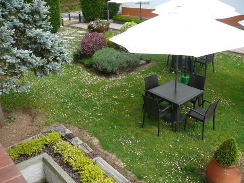 an overhead view of a table and chairs with an umbrella at Hotel el Pinar in Villapedre