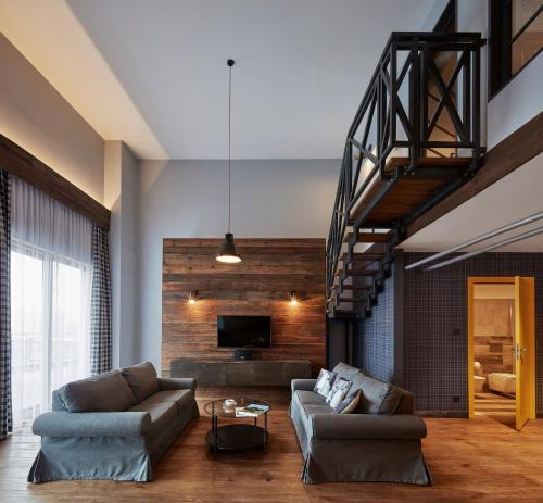 a living room with two couches and a tv at Salio Equisport Resort in Stryków