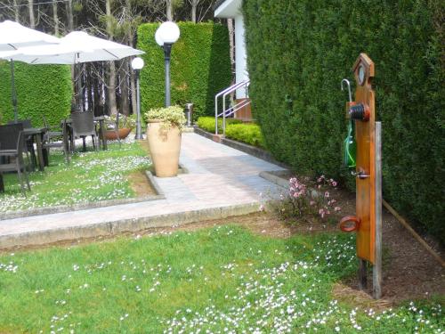 a garden with white flowers in the grass at Hotel el Pinar in Villapedre