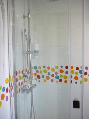 a bathroom with a shower with polka dots on the wall at Hotel el Pinar in Villapedre