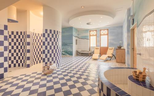 a bathroom with a checkered floor and a bathroom with the ocean at Hotel Post Hönigwirt in Kirchschlag