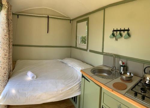 テンビーにあるHillcrest Hutの小さなベッドルーム(ベッド1台、シンク付)