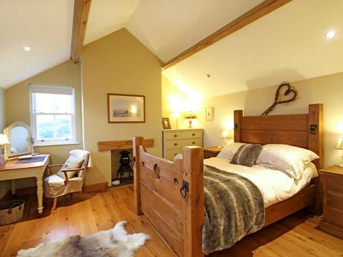ein Schlafzimmer mit einem Bett und einem Schreibtisch sowie ein Hund auf dem Boden in der Unterkunft Cae'r Dyni Caer Dyni in Criccieth