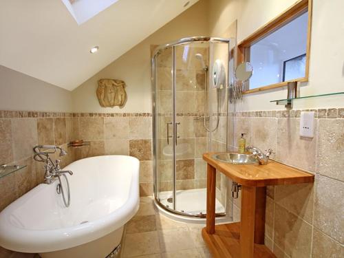 ein Badezimmer mit Badewanne, Waschbecken und Dusche in der Unterkunft Cae'r Dyni Caer Dyni in Criccieth