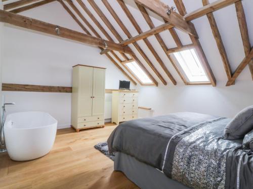 a bedroom with a large bed and a wooden floor at Grange Barn in Hessett