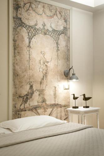 a bedroom with a tapestry hanging above a bed at Hotel Del Borgo in Bologna