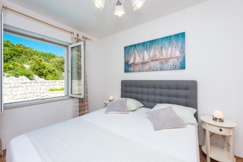 - une chambre avec un lit blanc et une fenêtre dans l'établissement Penthouse Leon, à Dubrovnik