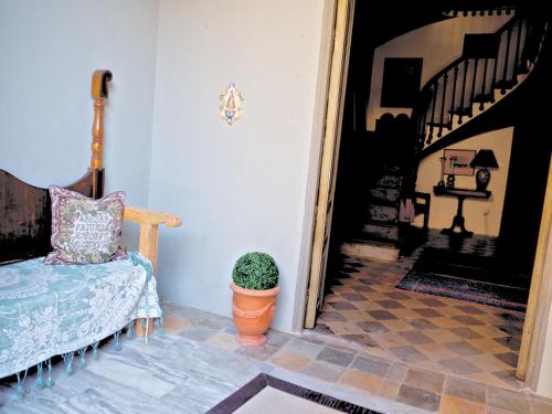 Habitación con cama y escalera con maceta. en Olmitos 3, Casa-Palacio Real Piedad, en Cehegín