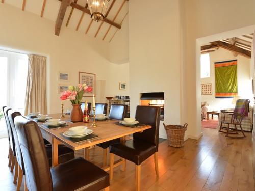 a dining room and living room with a table and chairs at Cefn Isaf in Porthmadog