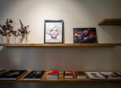a shelf with pictures and books on it at Schumacher Hotel Haifa in Haifa