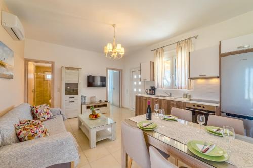 una cucina e un soggiorno con divano e tavolo di Villa George Sea View with pool - Triopetra a Triopetra