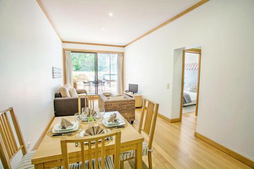 a dining room and living room with a table and chairs at Quinta Miramar in Funchal