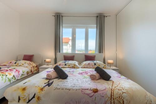 a bedroom with two beds and a window at Esther Apartment in Pula