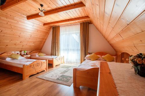 a attic room with two beds and a large window at Willa Kowala in Groń
