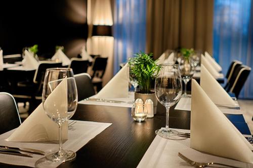 a table in a restaurant with wine glasses and napkins at Focus Hotel Premium Lublin in Lublin