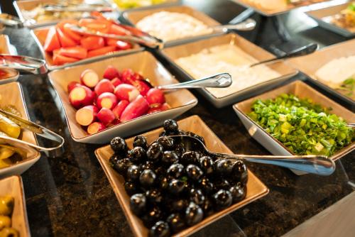 a buffet with bowls of fruits and vegetables in trays at Focus Hotel Premium Lublin in Lublin