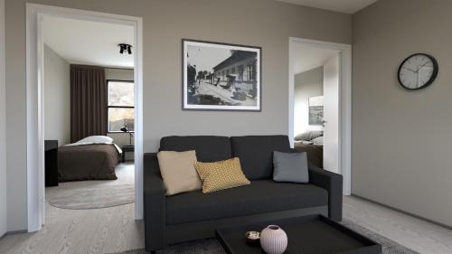 a living room with a couch and a clock on the wall at Naantali City Apartments in Naantali