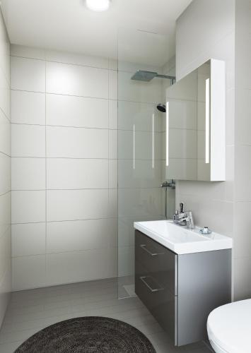 Naantali City Apartments في ناتالي: حمام أبيض مع حوض ومرآة