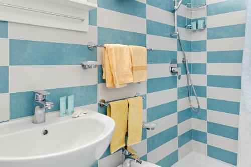 a bathroom with blue and white striped walls and a sink at Hotel Carmencita in Anacapri