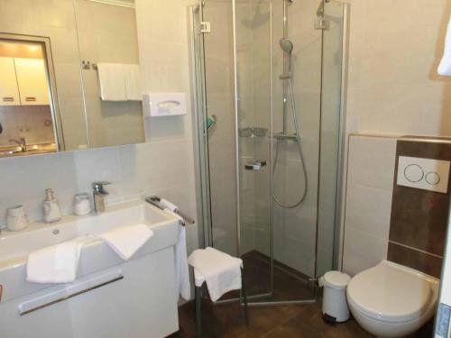 a bathroom with a shower and a toilet and a sink at Appartementhaus Margarita in Bad Füssing