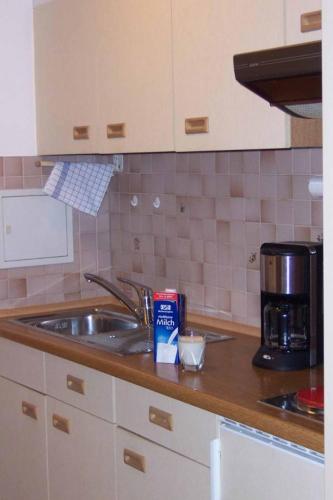 a kitchen counter with a sink and a coffee maker at Appartementhaus Margarita in Bad Füssing