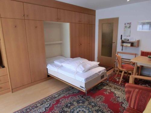 a bedroom with a bed and cabinets and a table at Appartementhaus Margarita in Bad Füssing