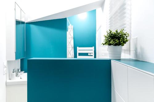 a bathroom with blue walls and a blue counter top at Au Fil de L eau in Albi