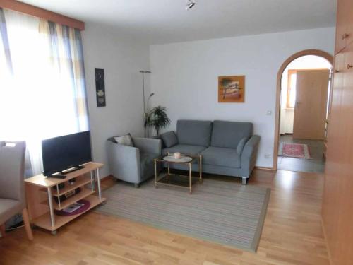a living room with a couch and a tv at Appartementhaus Margarita in Bad Füssing