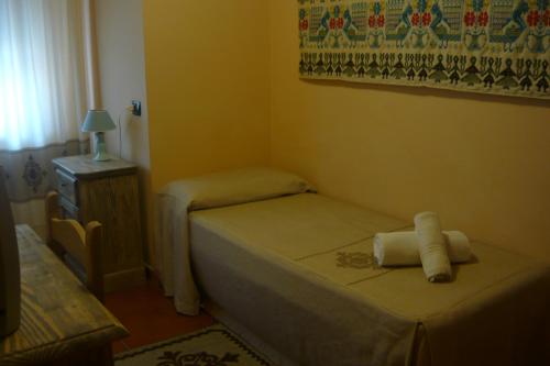a small bedroom with a small bed and a table at Hotel Plammas in Santa Maria Navarrese