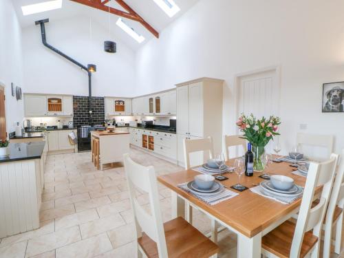 a kitchen and dining room with a wooden table and chairs at The Byre in Stockton-on-Tees