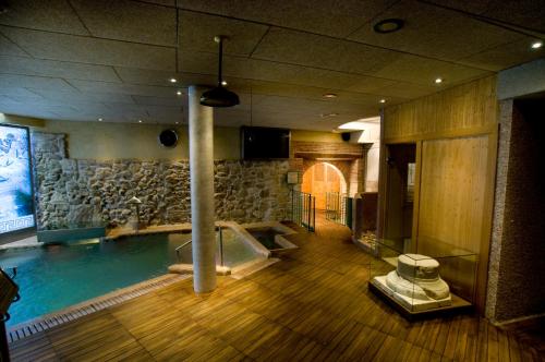 a swimming pool in a room with a tub at Hotel Spa La Casa Mudéjar in Segovia