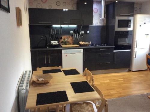 a kitchen with a wooden table and a kitchen with black cabinets at Number 7 Gouarec in Gouarec