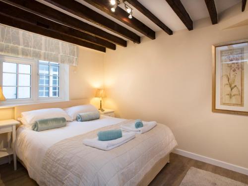 a bedroom with a large white bed with two pillows at The Coach House - Beaumaris in Beaumaris