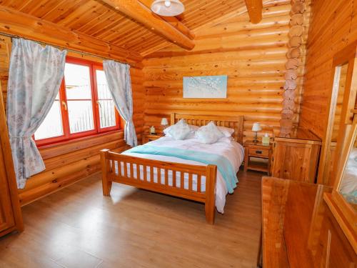 オーカムにあるYew Lodgeの丸太小屋のベッドのある寝室