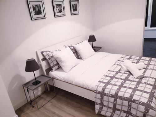 - une chambre avec un lit blanc et une couverture tressée dans l'établissement Brussels appartments luxury, à Bruxelles