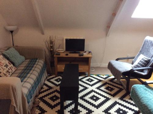 a living room with a couch and a desk with a computer at Number 7 Gouarec in Gouarec
