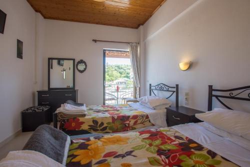 a hotel room with two beds and a window at Plessas Studios in Tsilivi