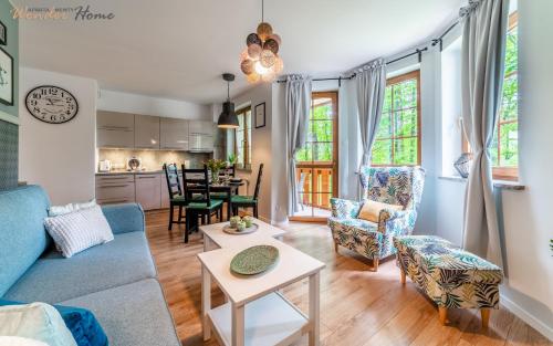 a living room with a blue couch and chairs at Wonder Home - Apartamenty Leśny Dom z balkonami niedaleko centrum - w cichej okolicy, blisko szlaków i terenów leśnych in Karpacz