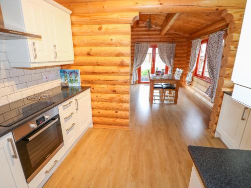 a kitchen and dining room in a log cabin at Beech Lodge in Oakham