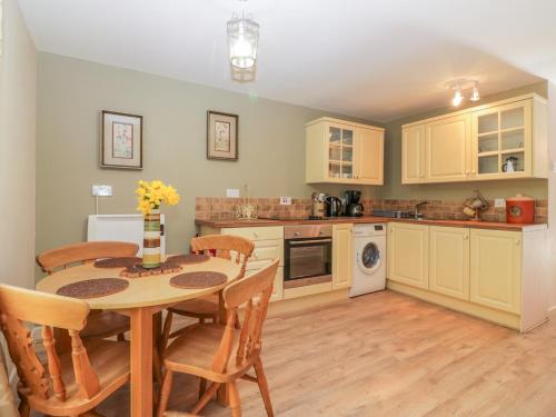 a kitchen with a table and chairs in a room at Bearscombe in Ivybridge